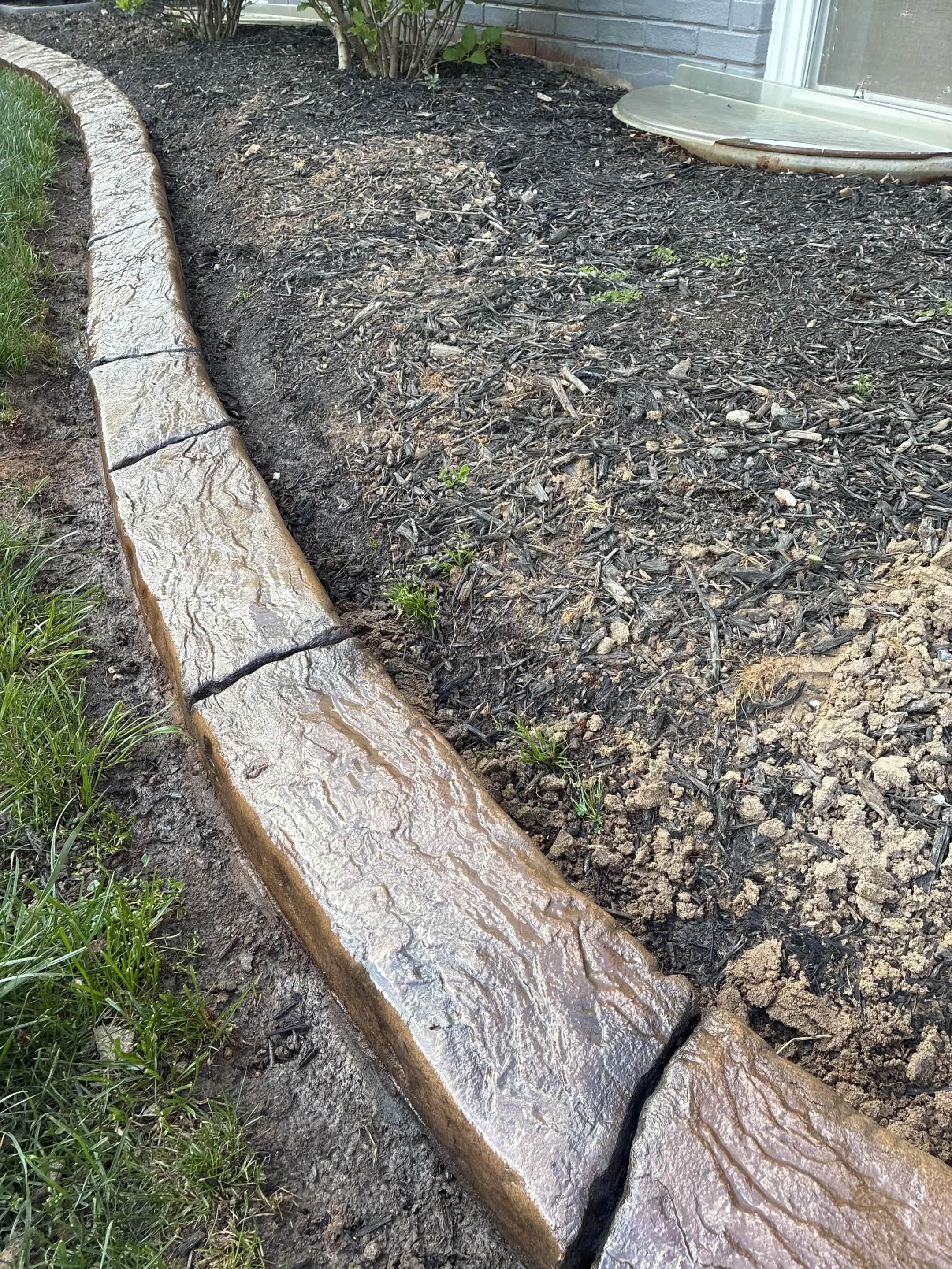 Continuous decorative residential curb and bed edge poured on site with a LOKE machine